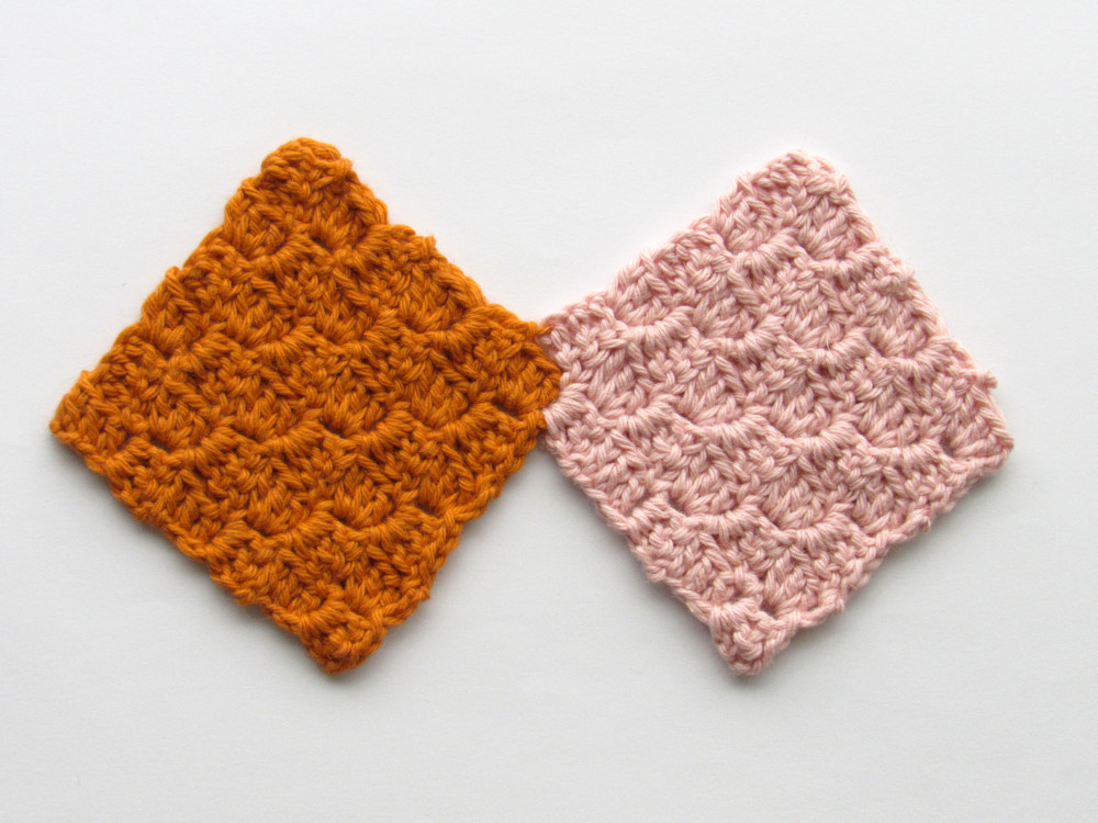 two connected C2C crochet squares, where the one on the left is a dark orange color and the one on the right is a light pink color