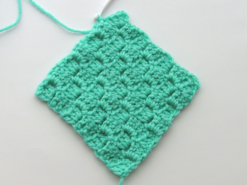 a completed C2C crochet square, made of green yarn