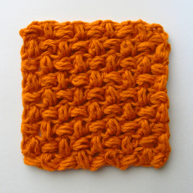 a photo of a dark orange c2c bean stitch crochet square