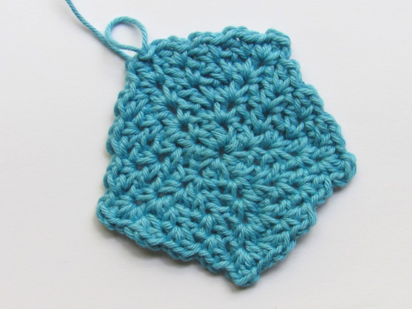 A blue wattle stitch crochet pentagon shaped piece