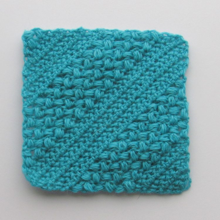 a photo showing a light blue c2c crochet herringbean stitch square.