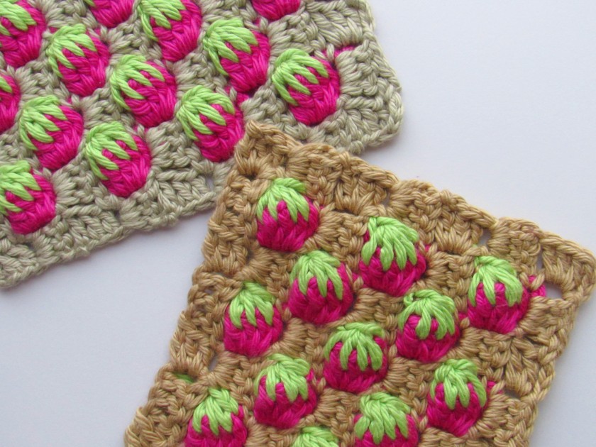 A close up photo of two overlapping c2c strawberry stitch squares